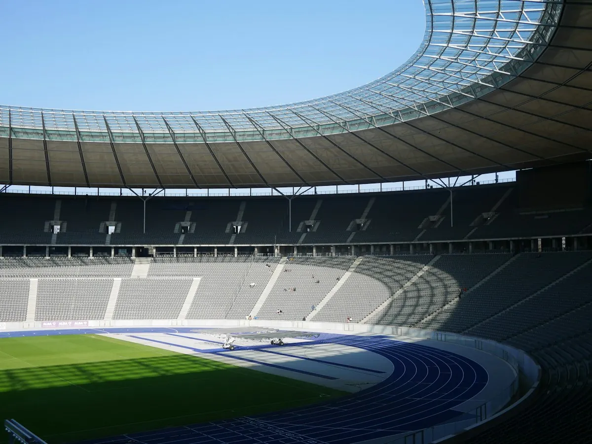 Interior de un estadio con pista de atletismo y gradas vacías
