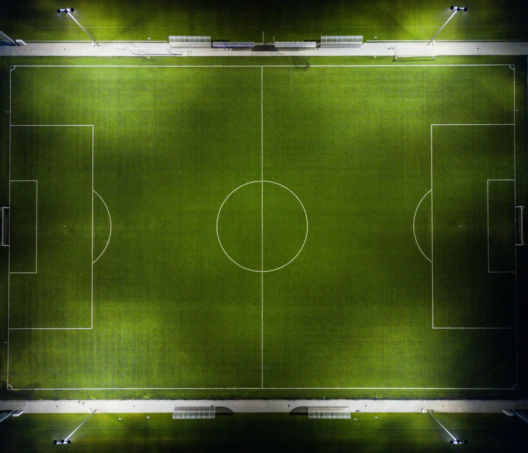 Vista aérea de una cancha de futbol iluminada de noche