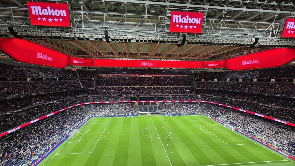 Estadio de futbol con anillos de publicidad de patrocinadores en las gradas